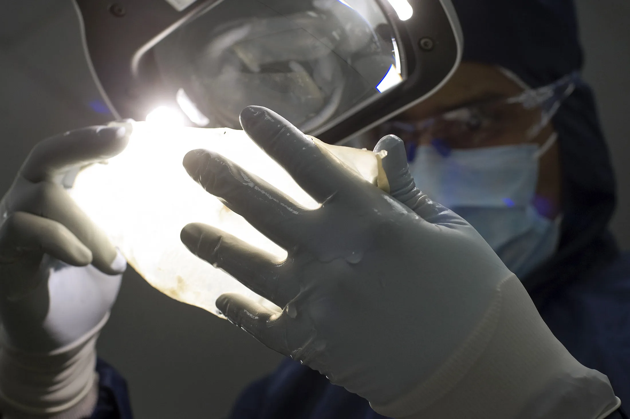 A worker inspects a membrane that will be used in the production of human heart valve replacements at the Medtronic assembly plant in Tijuana, Mexico.
