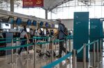 Travelers check in for a Cathay Pacific Airways Ltd. flight in the departure hall at Hong Kong International Airport on Aug. 8.