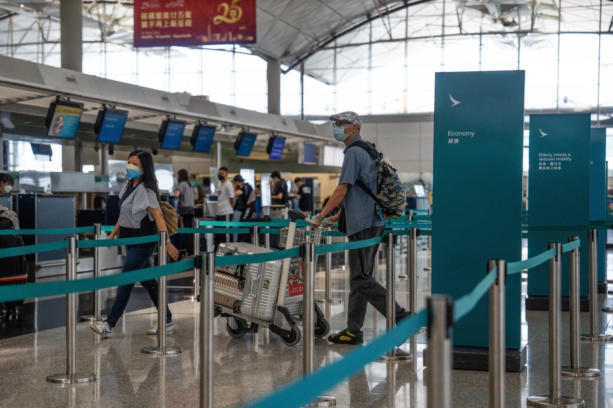 Travelers check in for a Cathay Pacific Airways Ltd. flight in the departure hall at Hong Kong International Airport on Aug. 8.