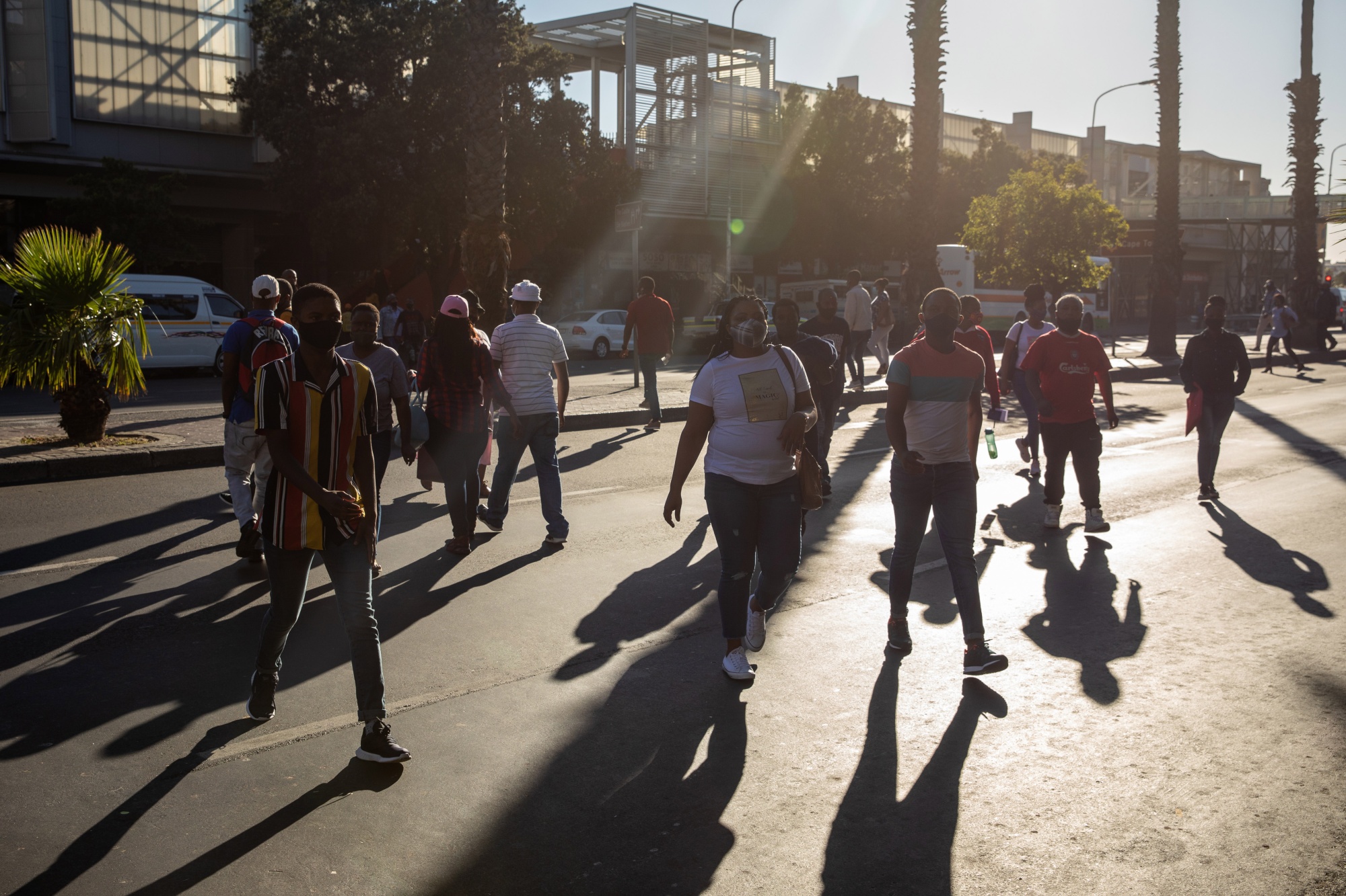 Commuters wearing protective face masks cross Strand Street in Cape Town.
