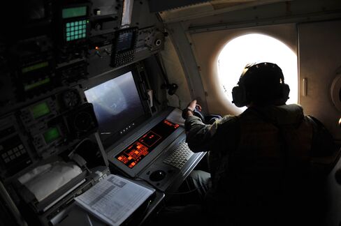 A search and rescue personnel looks out the window of a U.S. patrol aircraft searching the area in the Mediterranean Sea.