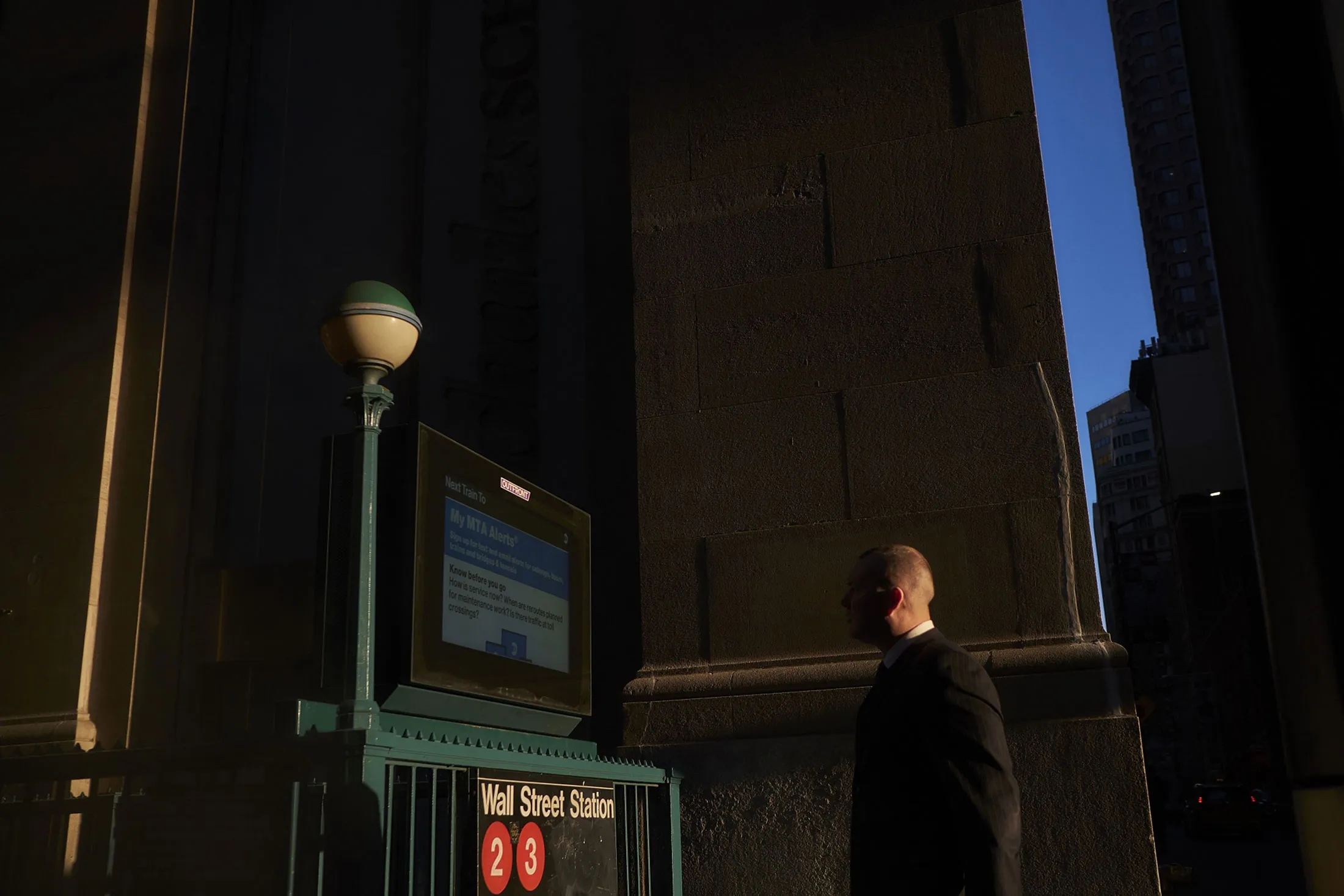A pedestrian walks toward&nbsp;an entrance to the Wall Street subway station near the New York Stock Exchange.