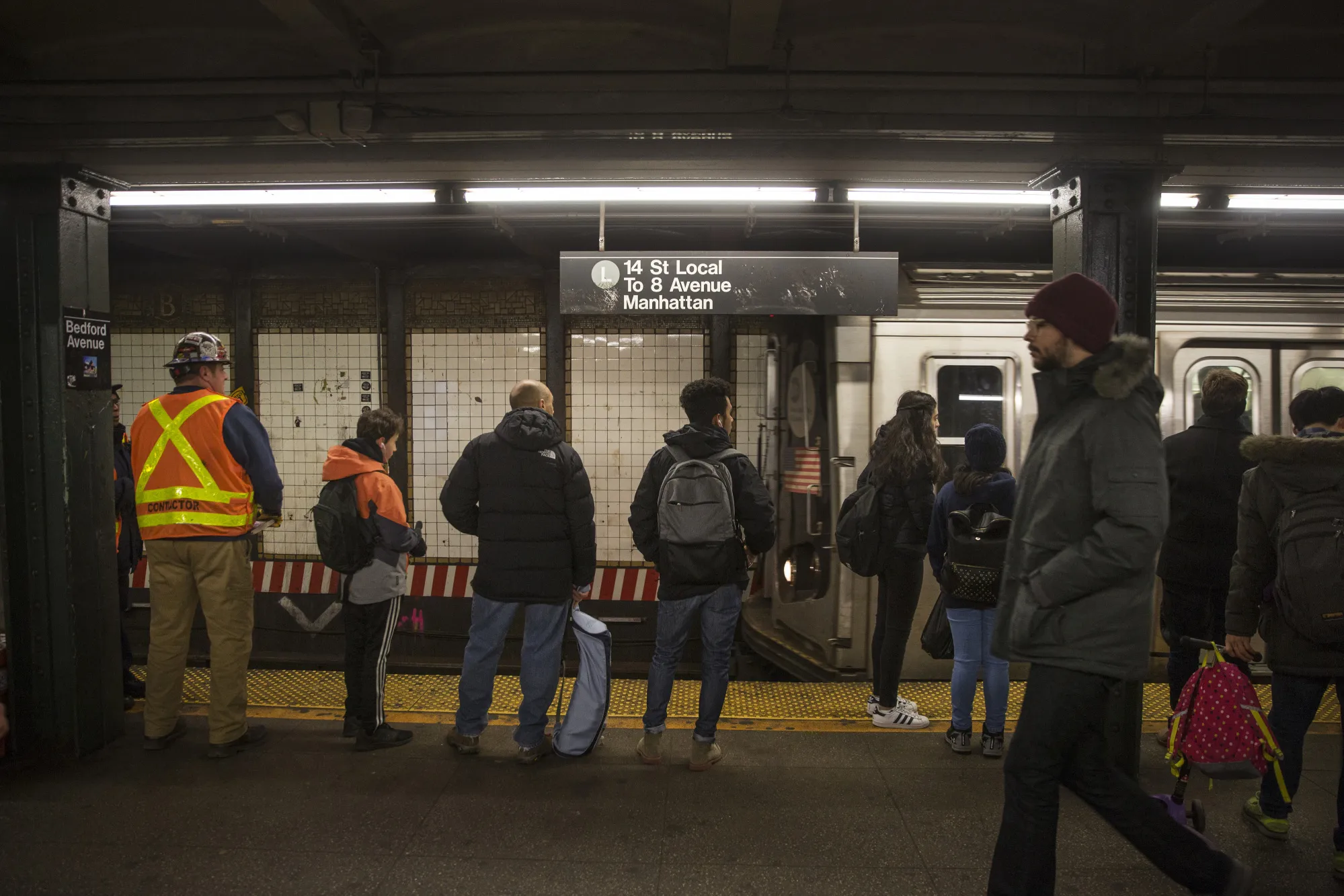 Commuters stand on the platform at a subway station in the Brooklyn borough of New York.