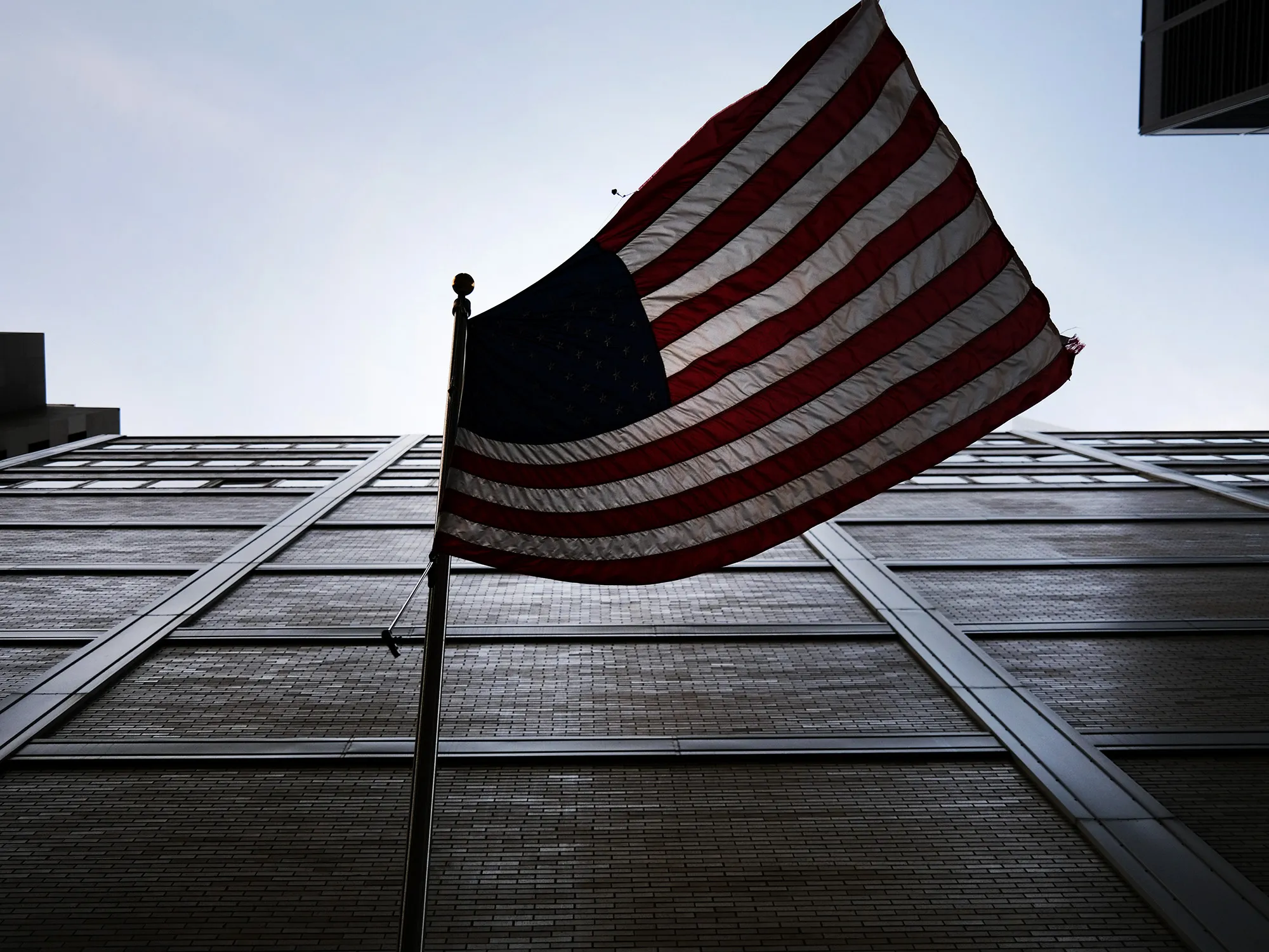 An American Flag hangs from a building in the Financial District of&nbsp;New York.