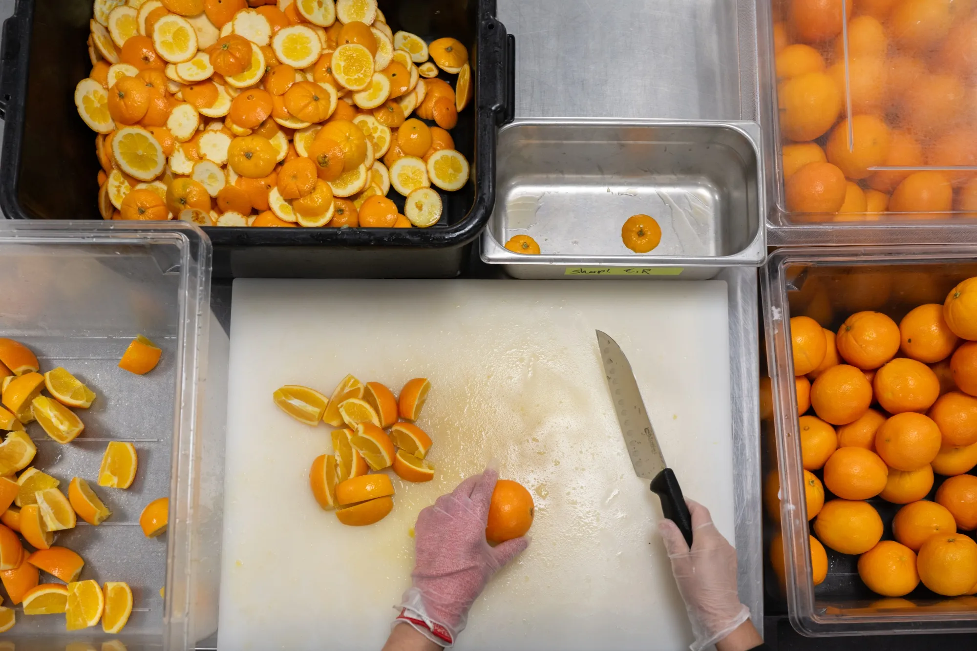 At the Google Bay View campus, a worker cuts oranges while collecting the scraps for composting in Mountain View.