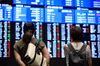 Visitors look at screens displaying stock indices at the Tokyo Stock Exchange (TSE), operated by Japan Exchange Group Inc. (JPX), in Tokyo, Japan, on Tuesday, July 24, 2018.