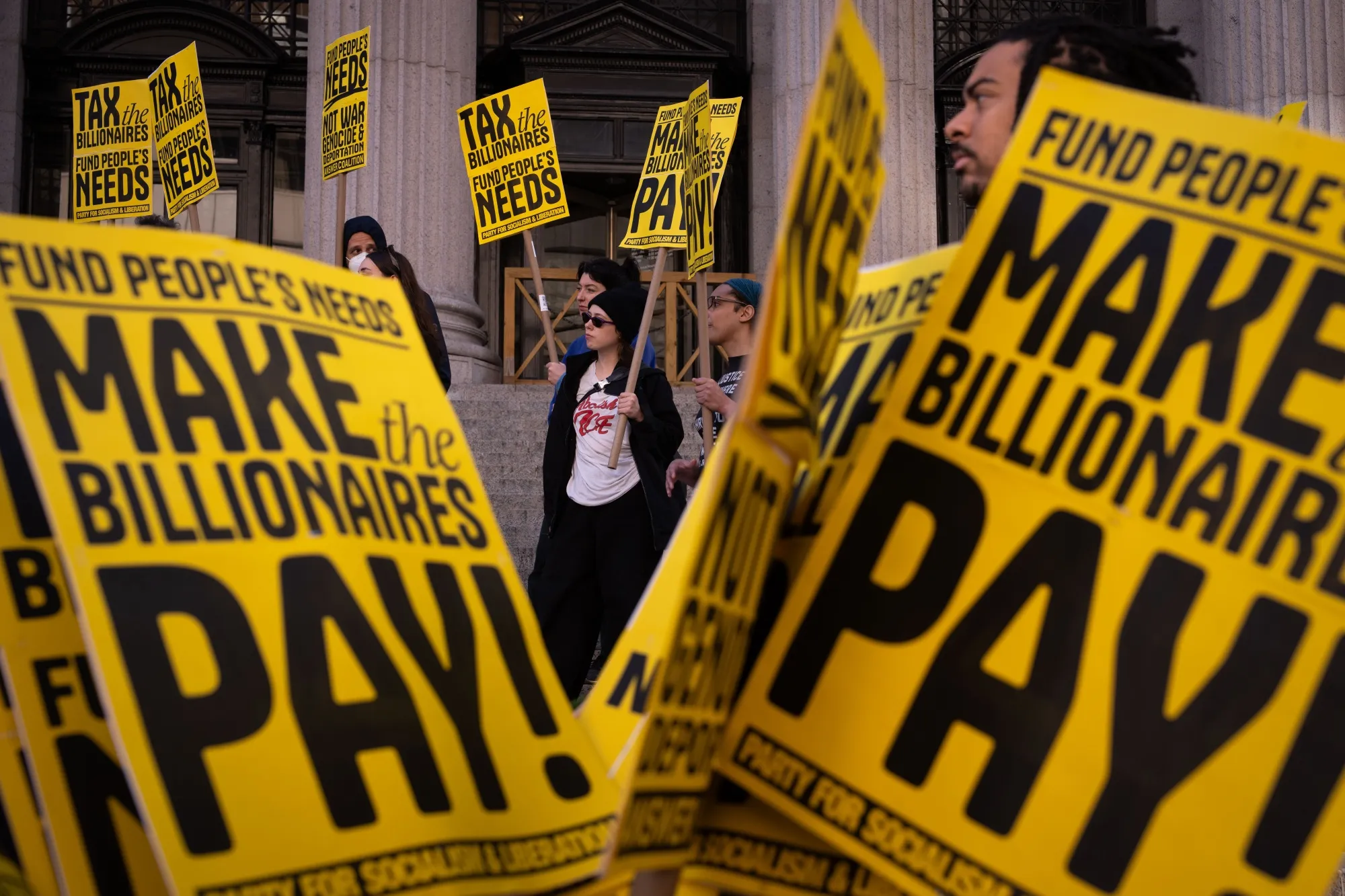 People protest calling for billionaires to pay more tax in New York City.