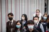 People wearing masks walk on a street in Kwun Tong district of Hong Kong, China.