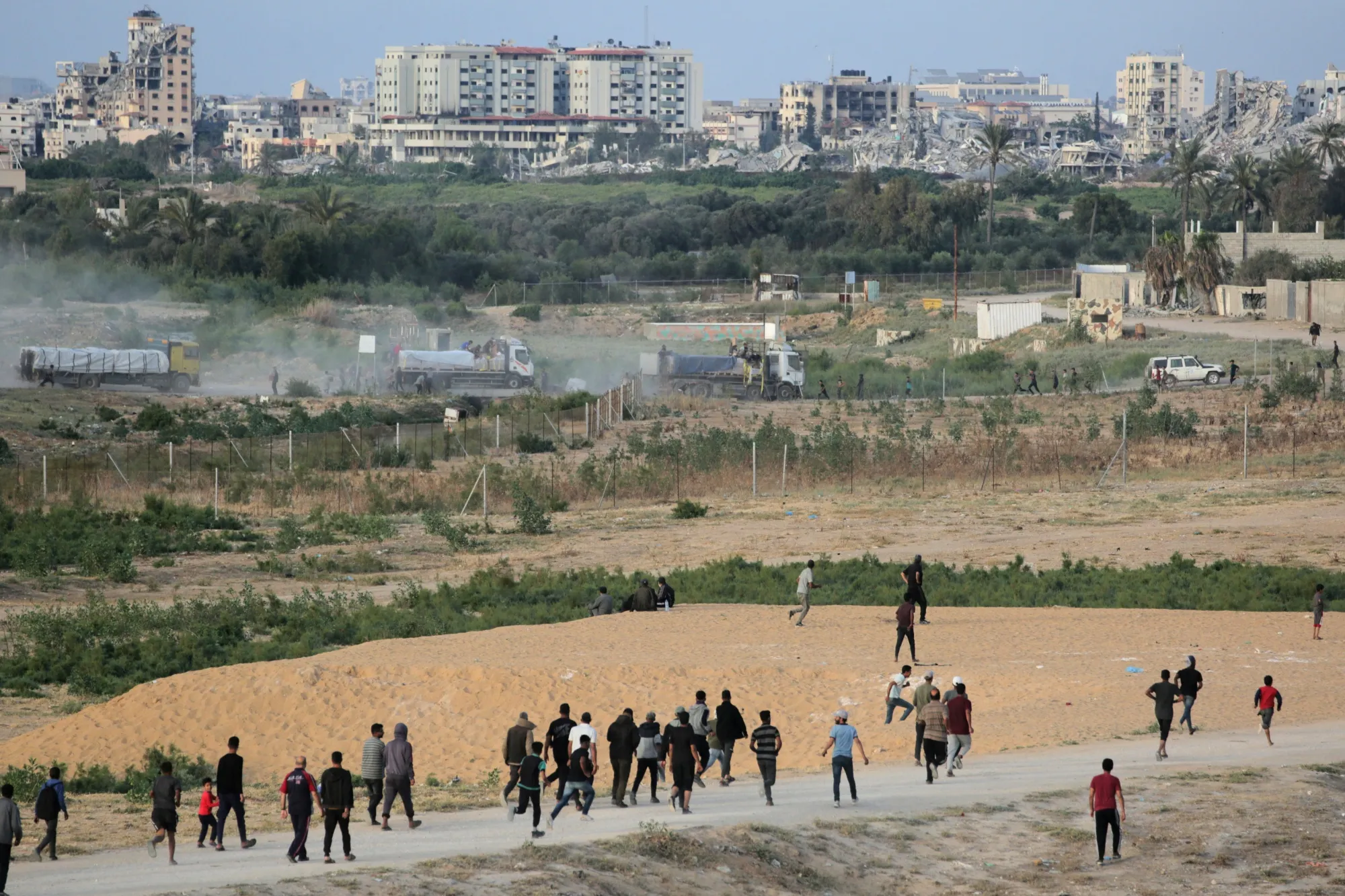 Palestinians rush towards trucks as they transport international humanitarian aid from the US-built Trident Pier in the central Gaza Strip.