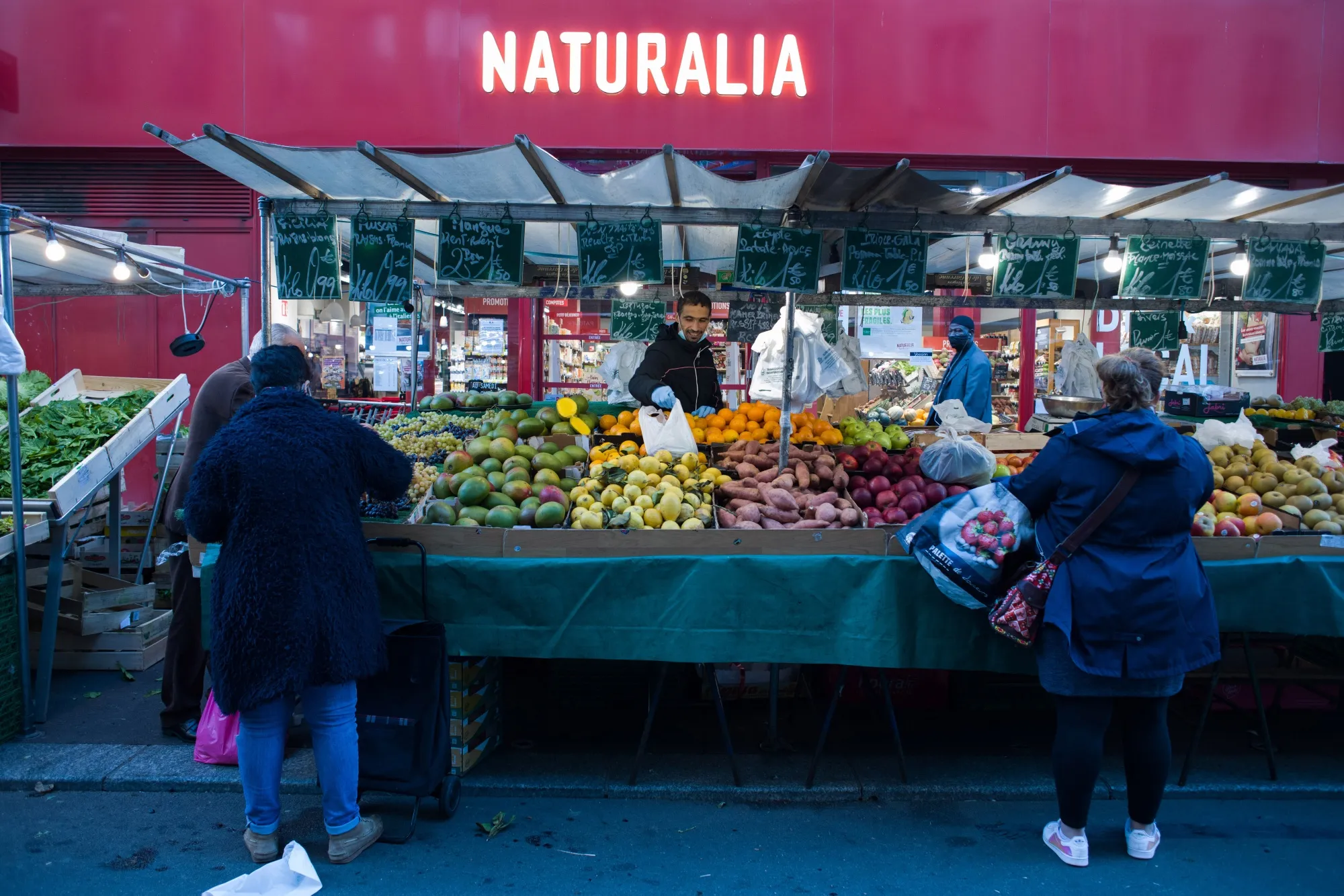 Customers shop for fresh produce at the Aligre market in Paris.