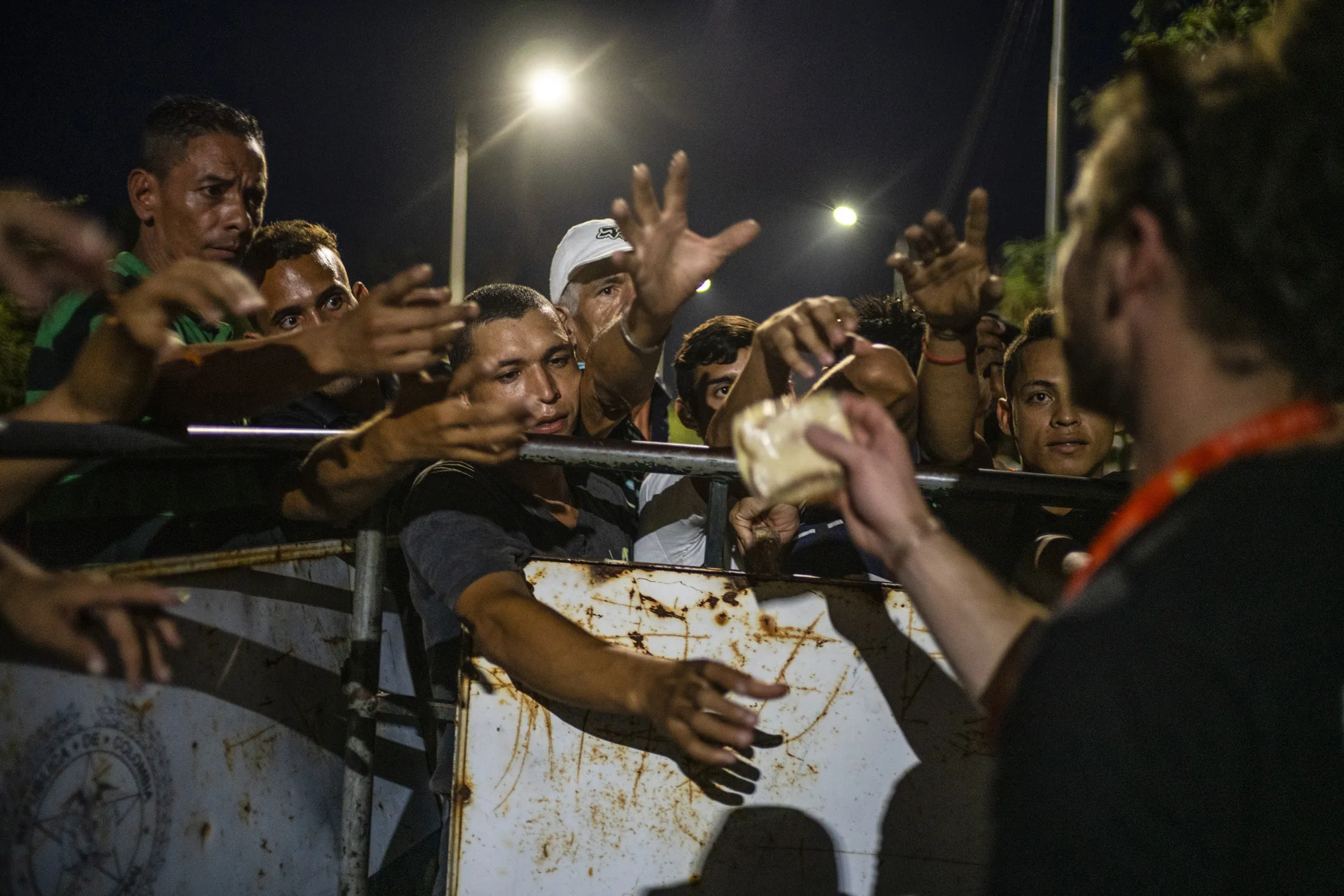A World Central Kitchen volunteer, right, distributes food at the Francisco de Paula Santander International Bridge in Cucuta, Colombia, on Thursday, Feb. 21, 2019.