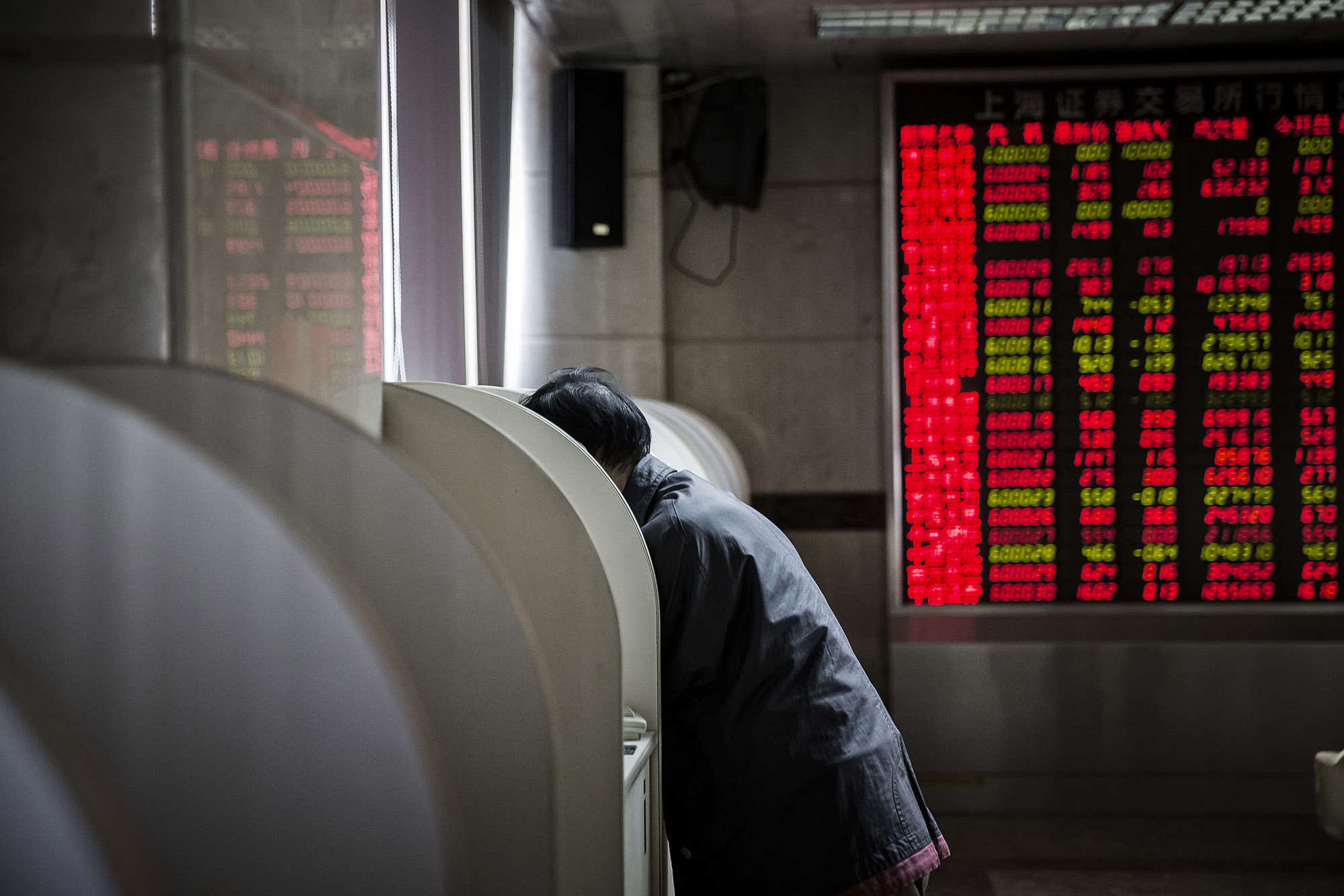 A woman stands at a trading terminal of a securities brokerage in Beijing.