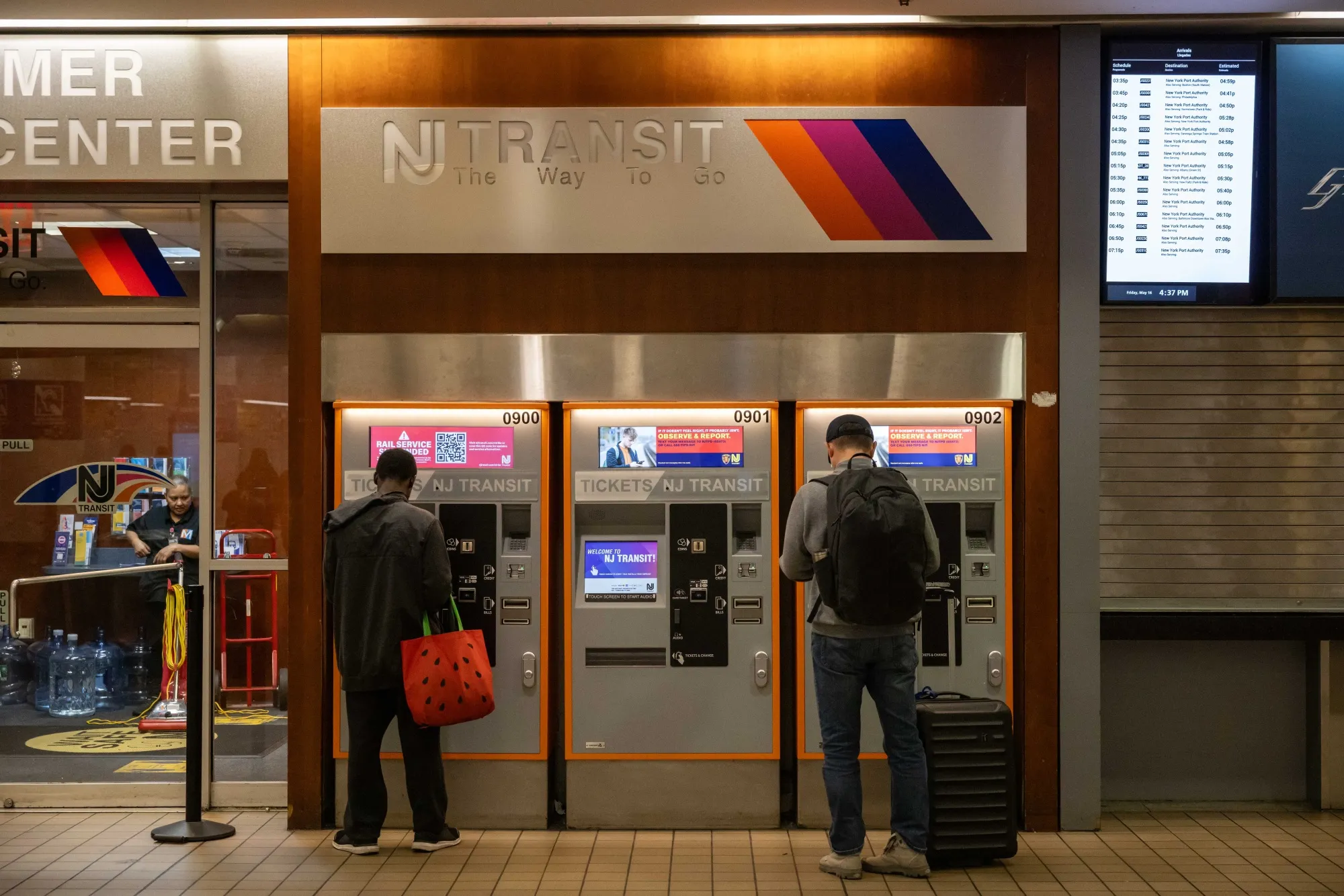 People stand at a NJ Transit ticketing booth at Port Authority Bus Terminal in New York on Friday, May 16, 2025.