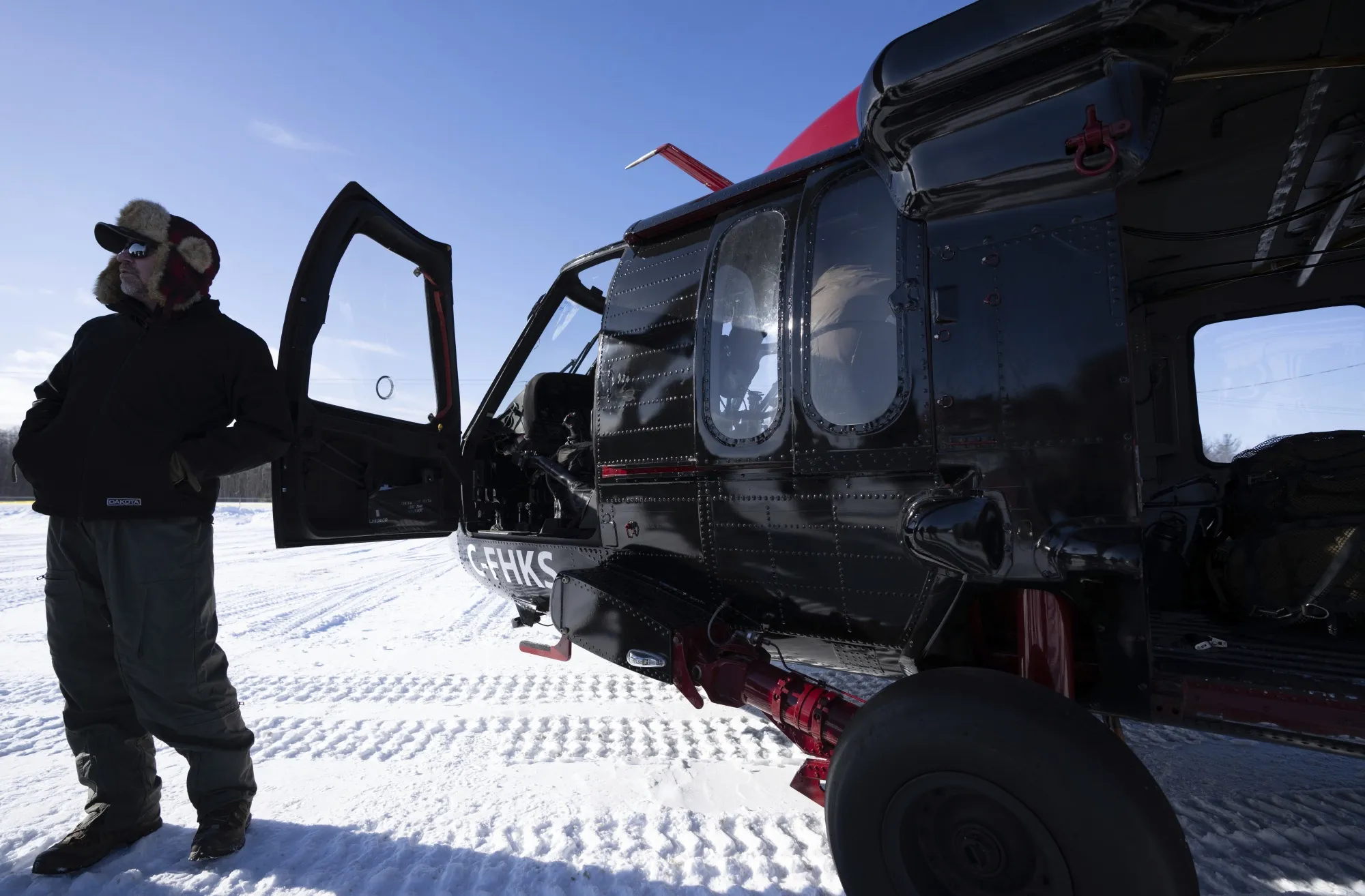A pilot stands outside a new Black Hawk helicopter acquired by the Royal Canadian Mounted Police to be used to patrol the Canada-US border, in St-Antoine-Abbe, Quebec, on Thursday.