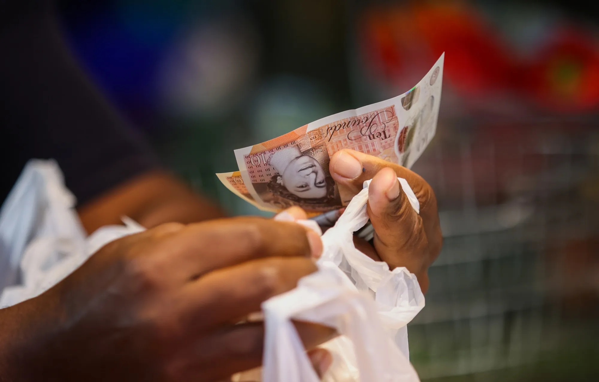 A shopper using cash at Walthamstow Market in London.