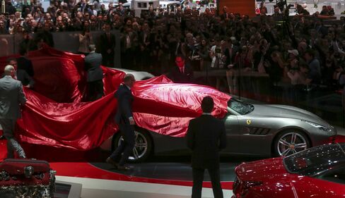 Workers remove the covers from a Ferrari GTC4 Lusso in Geneva.
