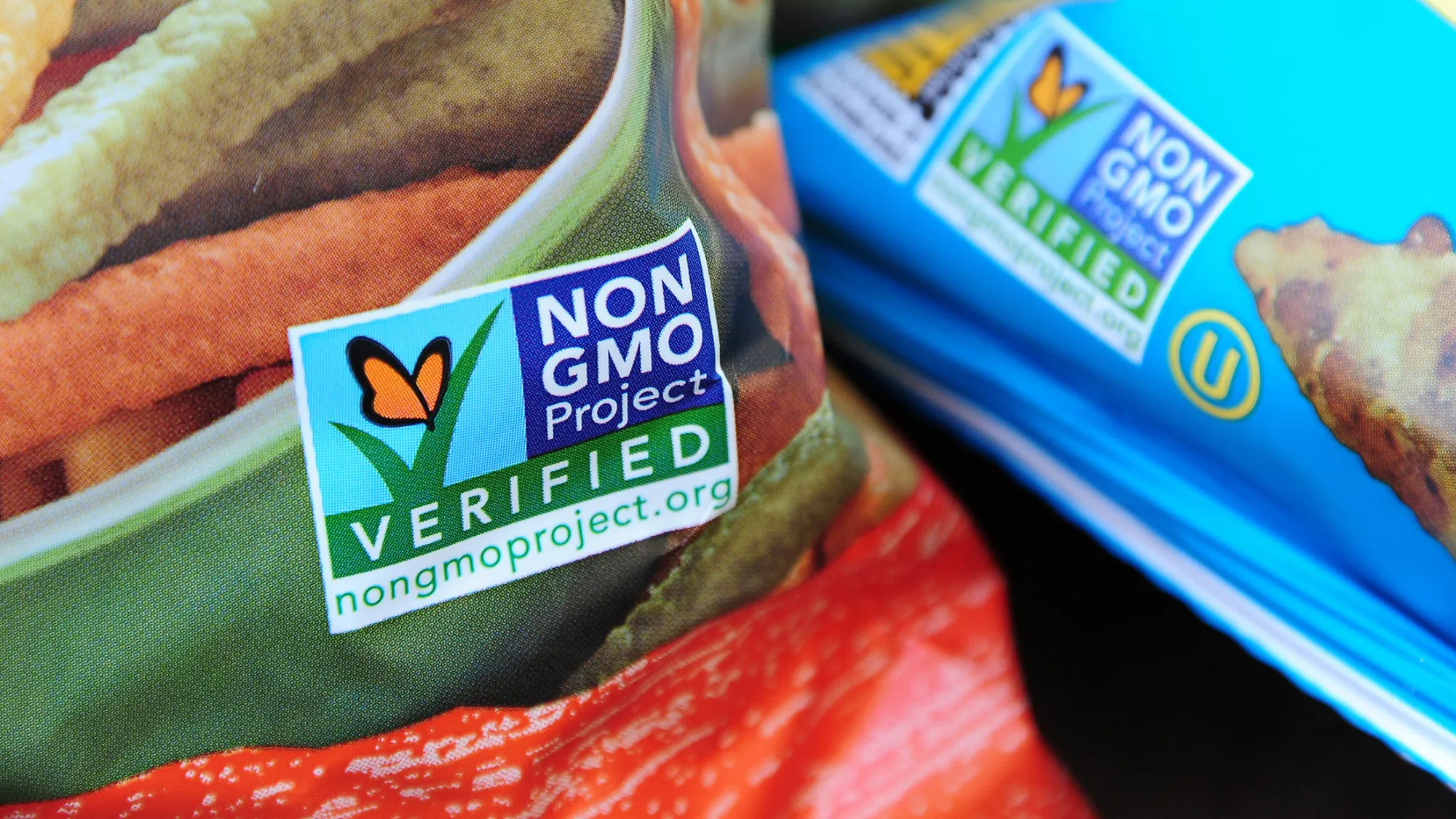 Labels on bags of snack foods indicate they are non-GMO food products.
