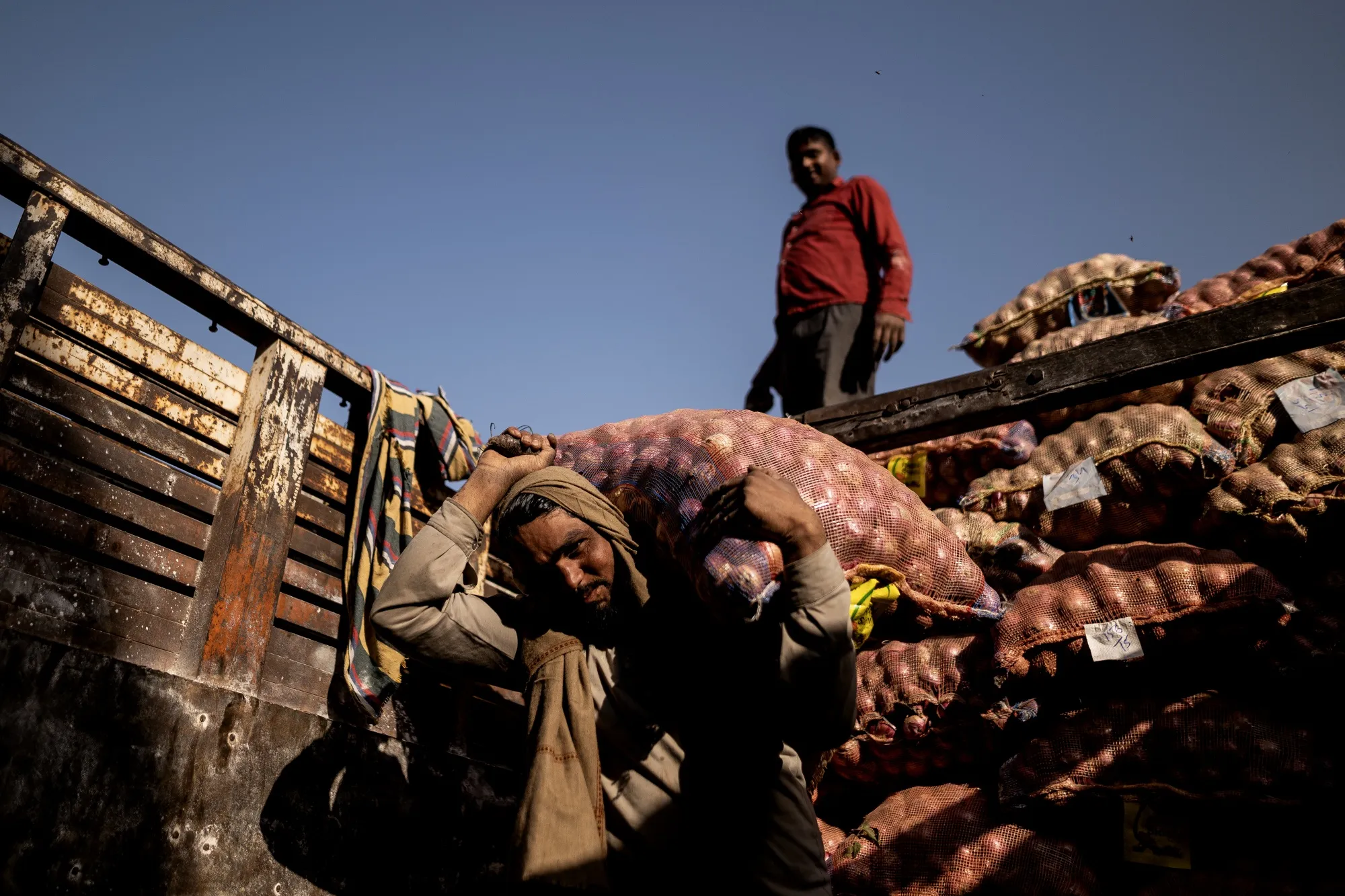 Workers unload sacks of onions from a truck at a wholesale market in Ghaziabad, Uttar Pradesh, India, in&nbsp;April.