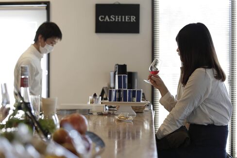 A customer, right, tastes a glass of wine, produced by Akiu Winery.