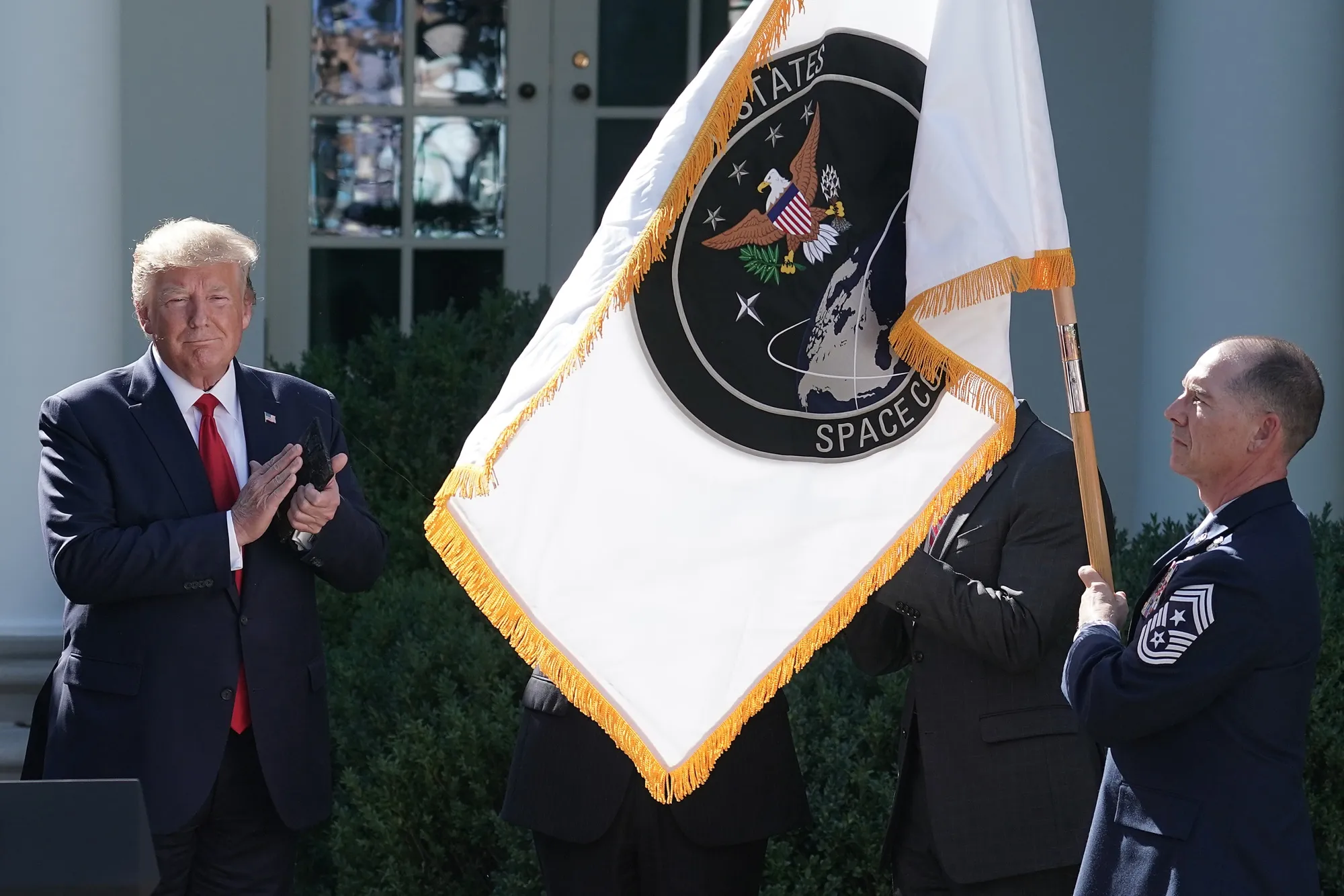 US President Donald Trump applauds as the flag for the new the US Space Command is revealed in 2019.