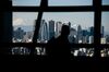 Mount Fuji stands beyond buildings as a visitor looks out at the skyline from an observation deck in Tokyo, Japan, on Friday, Jan. 11, 2019. Japan’s key inflation gauge slowed in the first back-to-back decline since April, highlighting the difficulty of the Bank of Japan’s price goal ahead of its policy meeting next week.