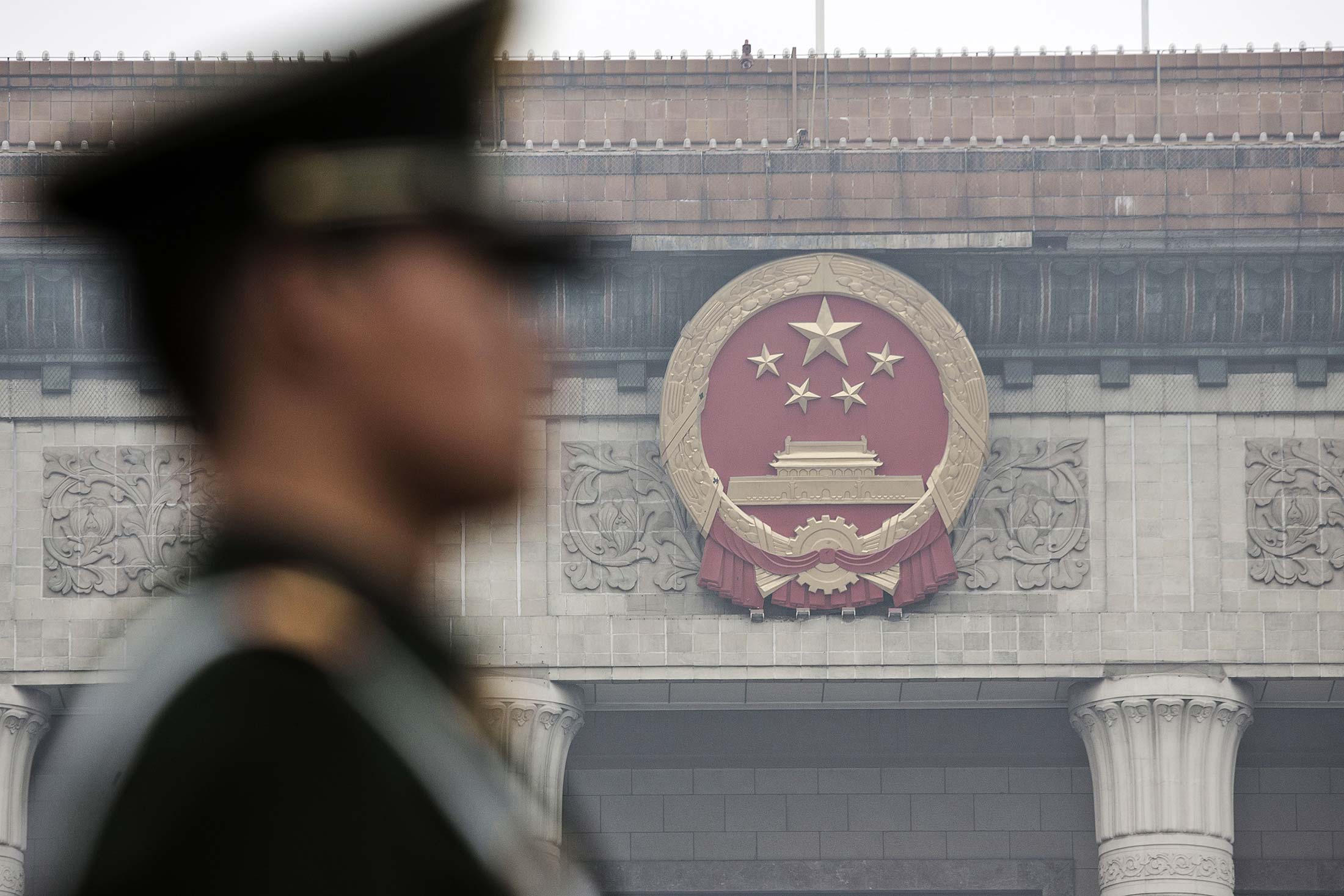 A paramilitary police officer stands guard in front of the Great Hall of the People in Beijing, China.
