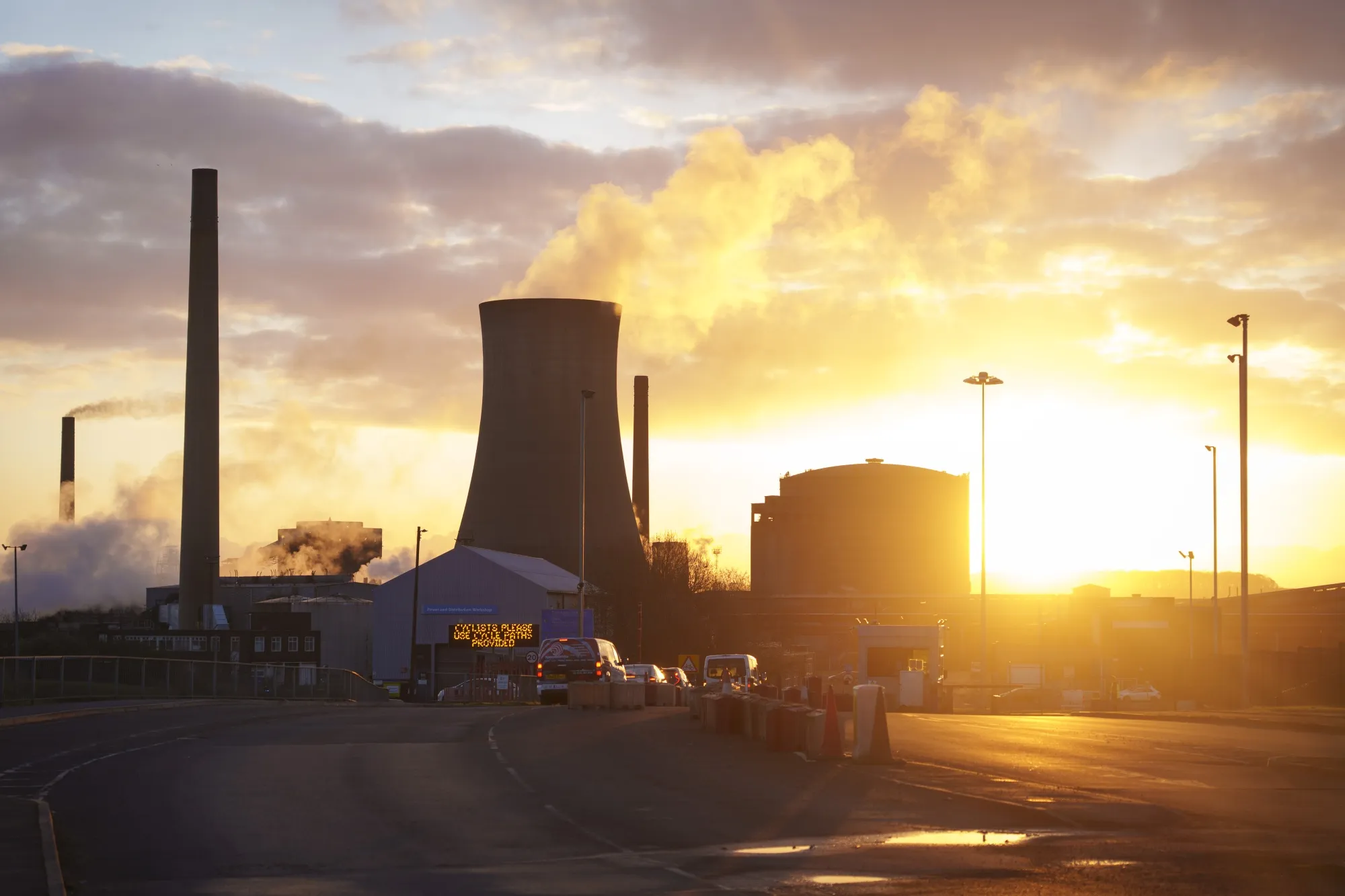 The sun rises behind chimneys at the British Steel Ltd. plant in Scunthorpe, UK.