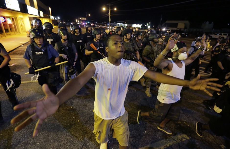 People are moved by a line of police as authorities disperse a protest in Ferguson early Wednesday, August 20, 2014.