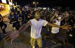 People are moved by a line of police as authorities disperse a protest in Ferguson early Wednesday, August 20, 2014.