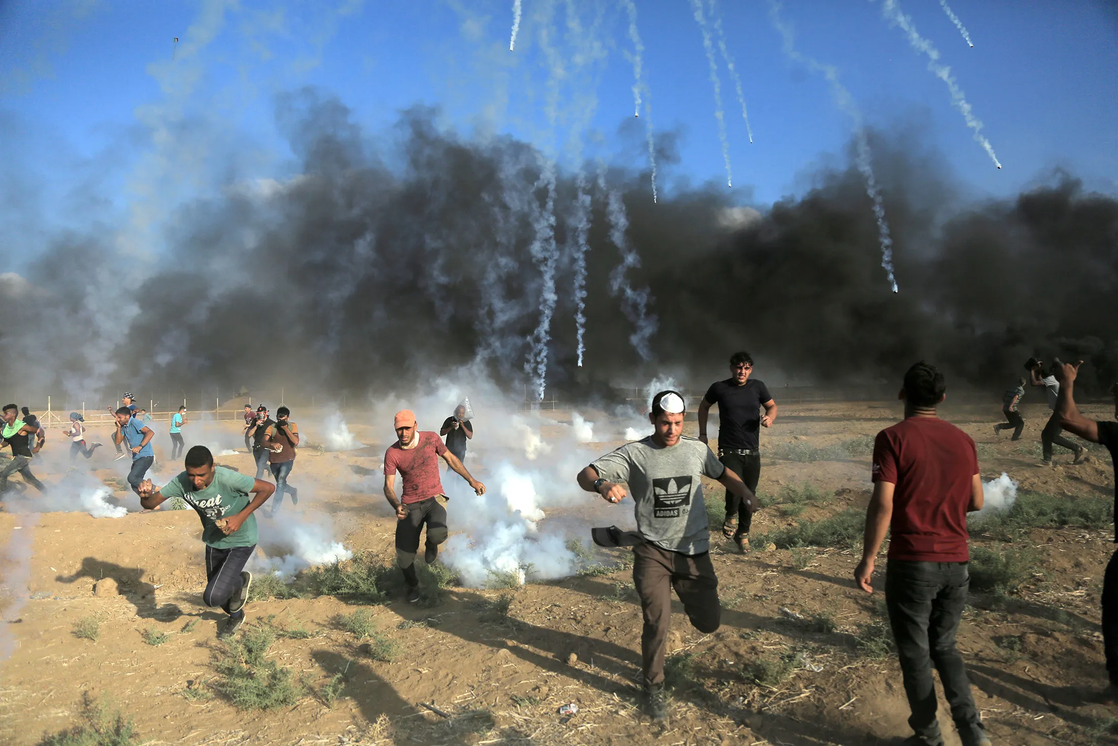 Tear gas canisters fired by Israeli forces land amidst protesters during a demonstration along the border with Israel east of Gaza City on July 13.&nbsp;