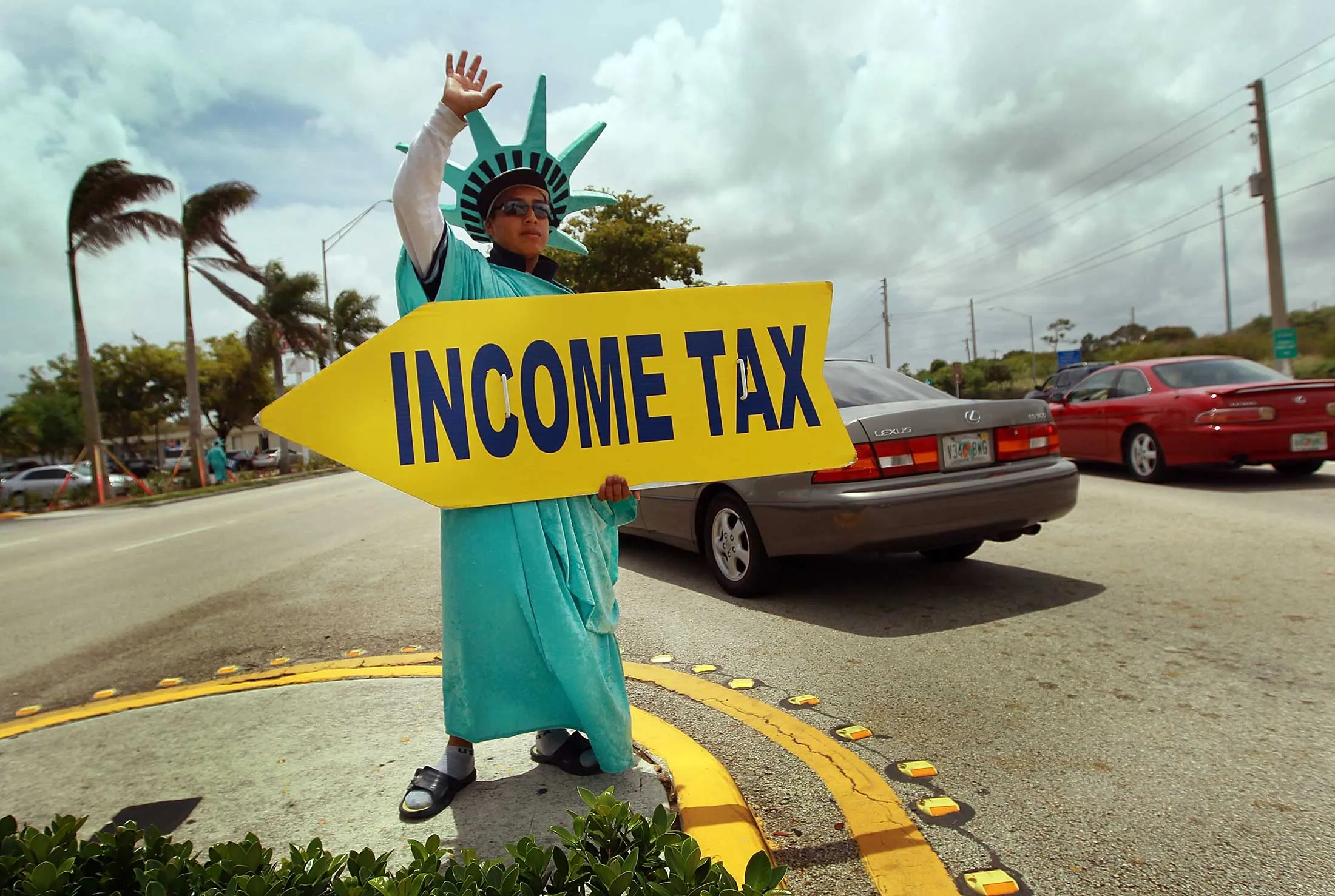 Felipe Castro holds a sign advertising a tax preparation office on April 14, 2010, in Miami.