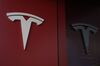 A Tesla Inc. logo is reflected in the glass of a closed showroom at a nearly-empty shopping mall in San Diego, California, U.S., on Tuesday, May 5, 2020. Emptied out malls and hotels across the U.S. have triggered an unprecedented surge in requests for payment relief on commercial mortgage-backed securities, an early sign of a pandemic-induced real estate crisis.