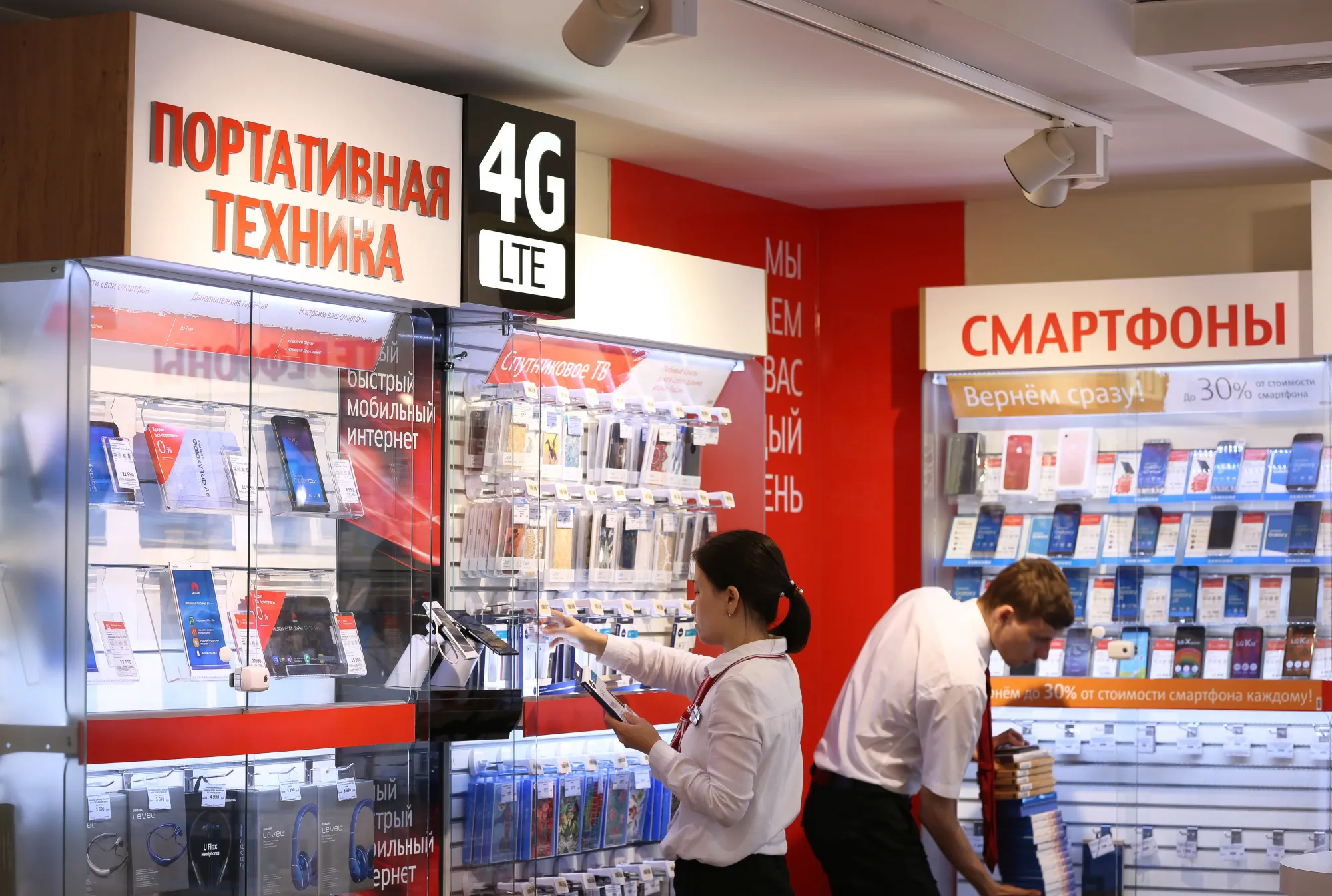 Employees arrange product displays inside a Mobile TeleSystems PJSC (MTS) mobile communications store in Moscow.