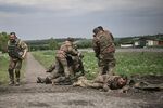 Ukrainian servicemen assist comrades near the front line in the embattled Donbas on May 21.