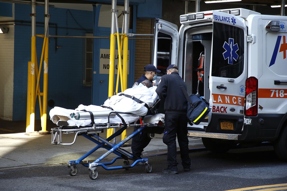 Emergency medical technicians move a Covid-19 patient from Mt. Sinai Morningside Hospital into an ambulance during a period of shortages of beds and equipment in New York City.
