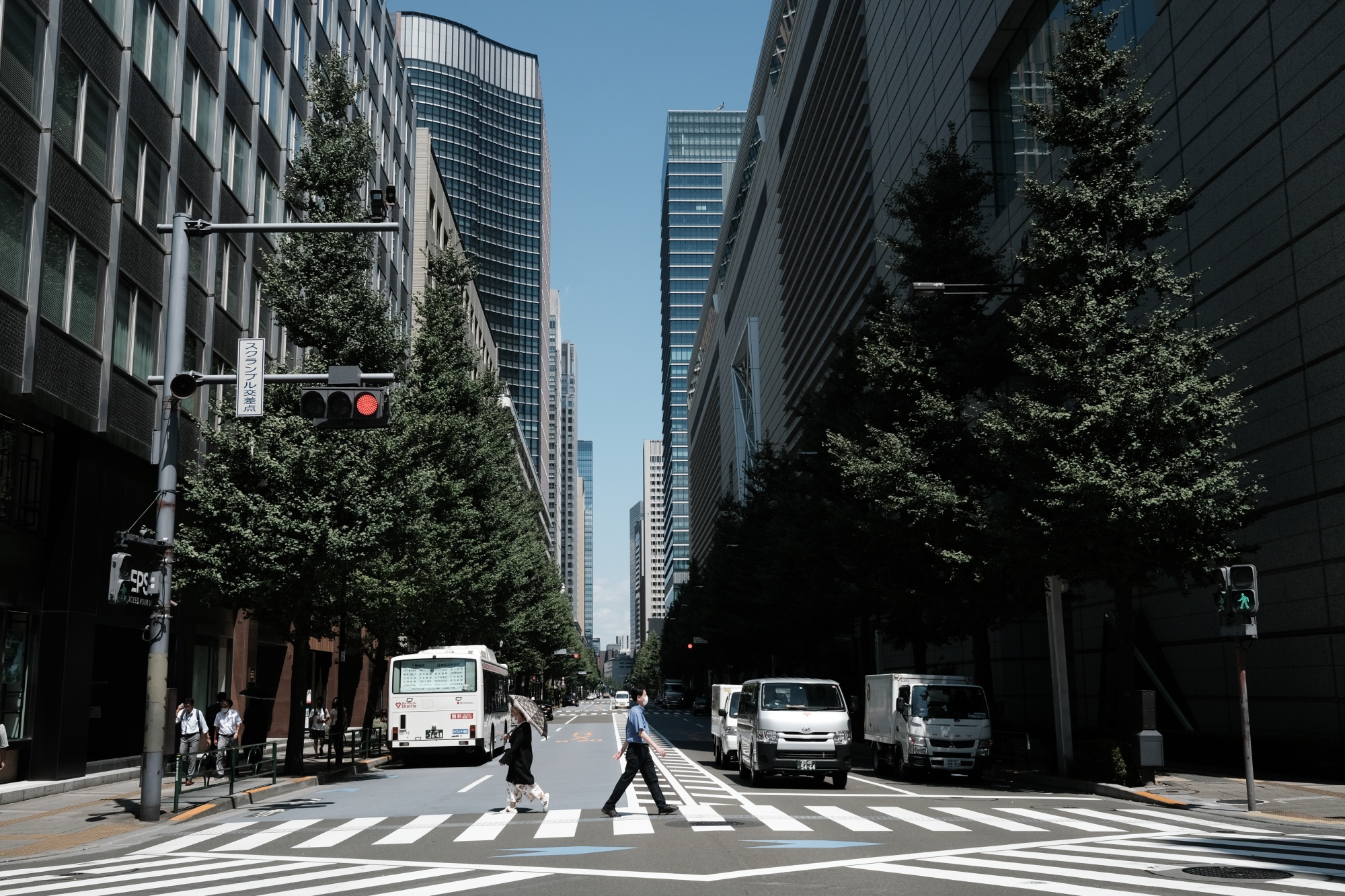 People cross an intersection in the Yurakucho District of Tokyo, Japan, on Friday, Aug. 28, 2020. Japan is considering how to make social-distancing rules more binding as it confronts a wave of coronavirus cases larger than the one that prompted a state of emergency in April-May, according to Economy Minister Yasutoshi Nishimura. who heads the country’s virus response.