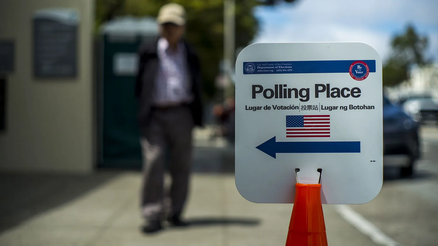 A pedestrian walks toward a polling place sign during the presidential primary election in San Francisco on June 7, 2016.
