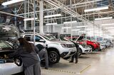 Technicians work on used vehicles at a plant in Flins, France
