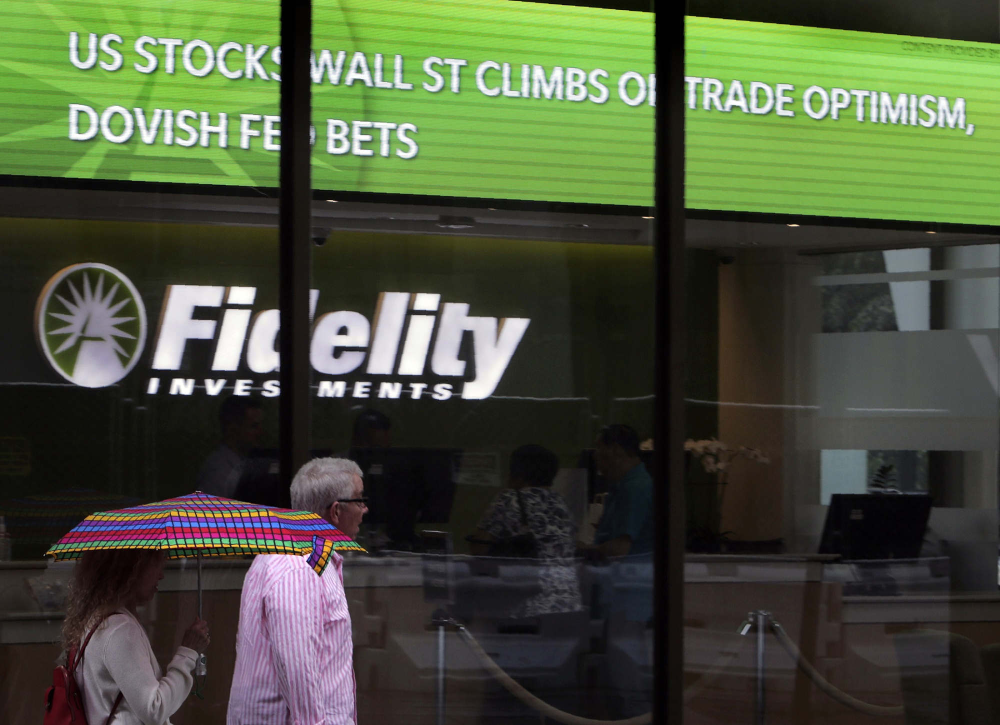 People walk past a&nbsp;Fidelity Investments news scroll board in Boston.&nbsp;