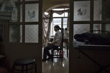 Jiang Xueying sits on a chair at her traditional medicine therapy clinic in Xinteng Township of Jiaxing, China, on Monday, November 22, 2016. Ms. Jiang's sister Jiang Chuying died recently from cancer and had used Oxycontin in large quantities towards the end of her life. Photographer: Qilai Shen/Bloomberg