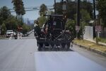 A worker applies a reflective pavement coating to a street in the&nbsp;Pacoima&nbsp;area of&nbsp;Los Angeles&nbsp;on&nbsp;July 19.&nbsp;