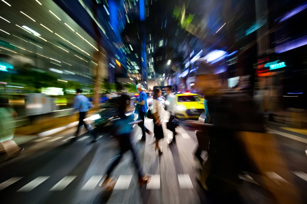 Commuters cross a road at night in the central business district of Singapore, on Wednesday, Oct. 28, 2015. Singapore's third quarter unemployment rates are scheduled to be released on Oct. 29 by the Ministry of Manpower.