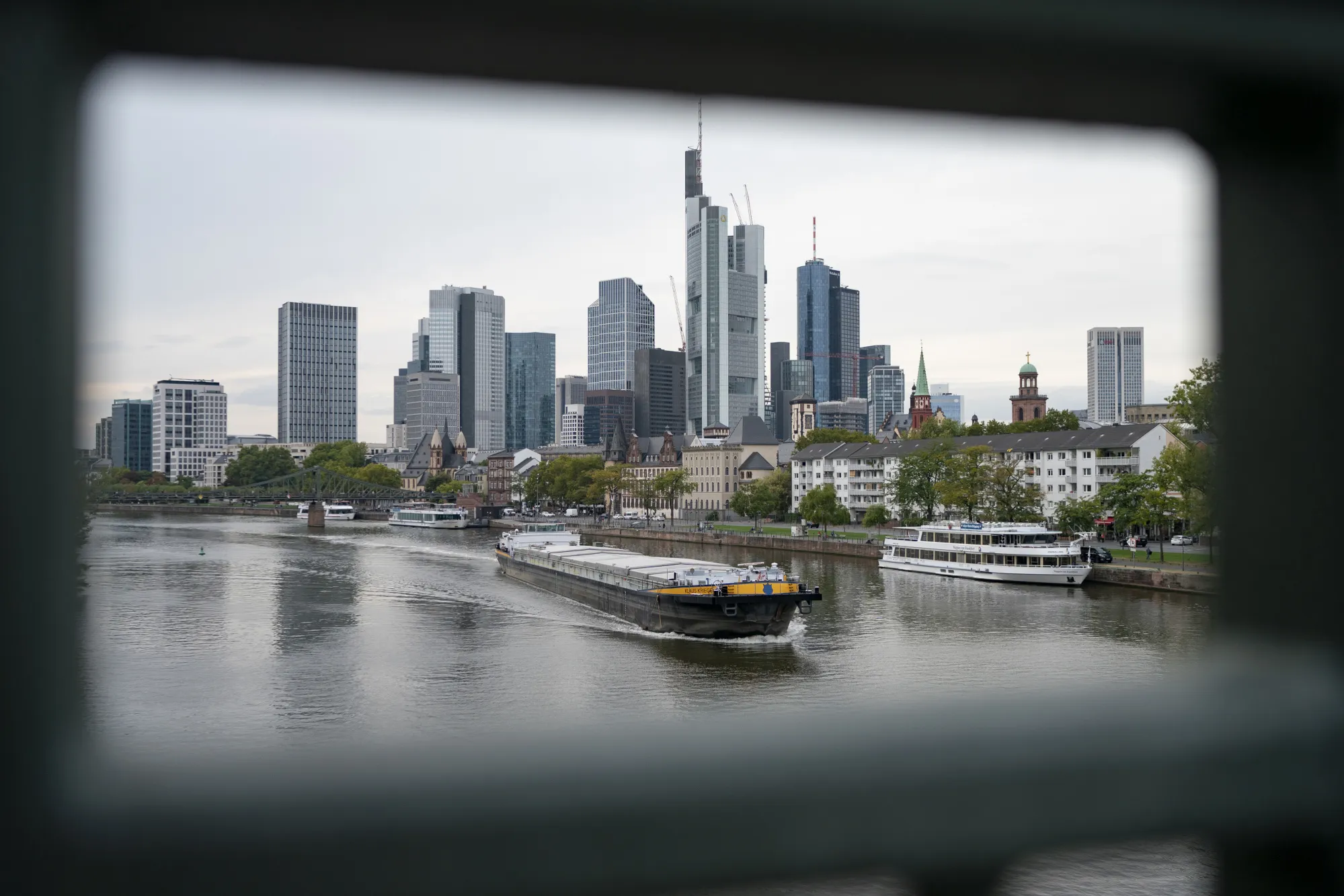 A barge travels on the River Main as skyscrapers stand beyond in the financial district in Frankfurt.