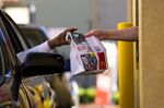 A customer receives an order from an employee at the drive-thru of a McDonald's restaurant in San Pablo, California.