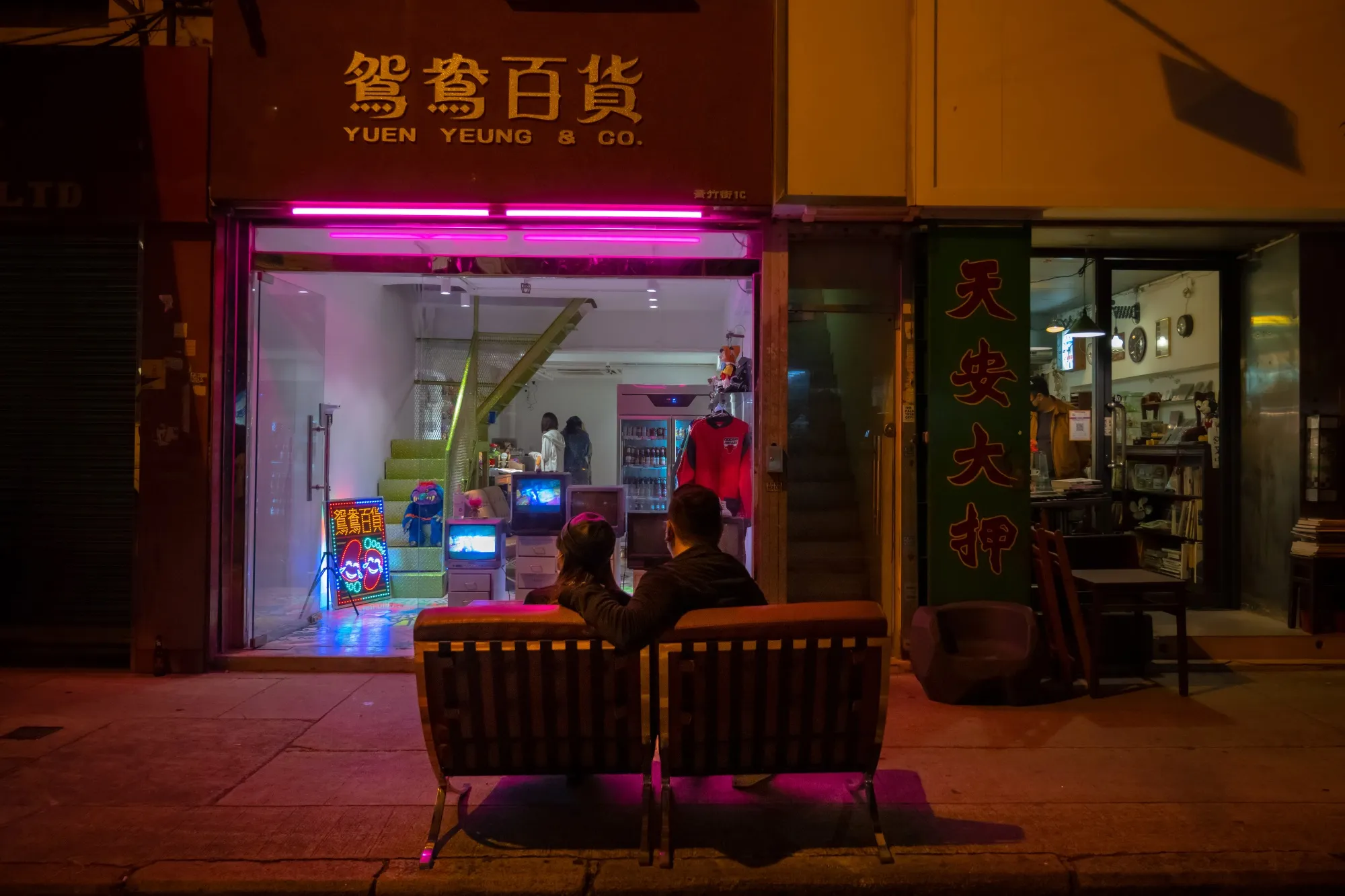 A couple sit watching televisions in the window of a store in Hong Kong's Sham Shui Po.&nbsp;