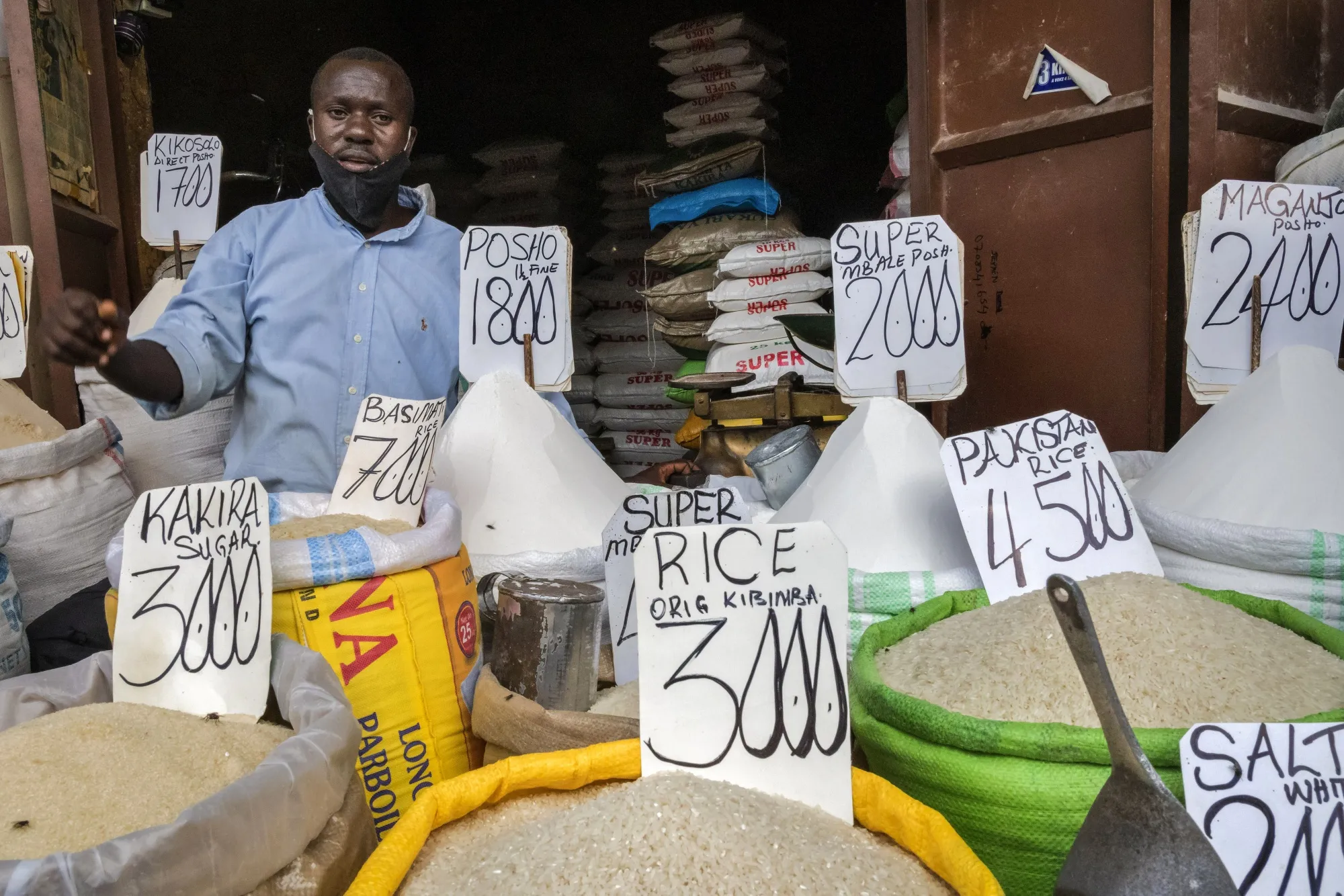 Prices in Ugandan shillings displayed on sacks of fresh grain on a stall at Owino Market in Kampala, Uganda.