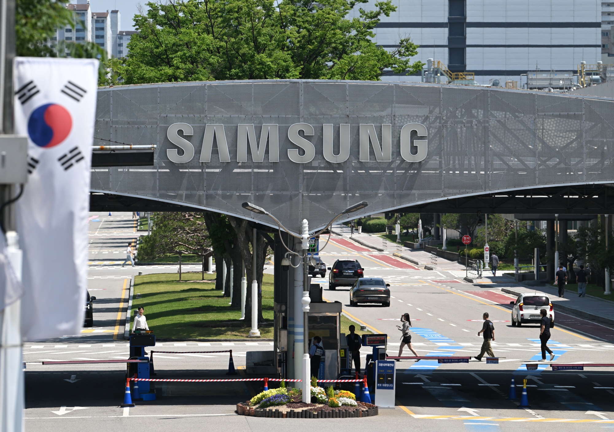 The logo of Samsung Electronics is seen on a gate at the company's headquarters in Suwon on May 22, 2026. Samsung labour union members will begin voting on May 22, on a tentative wage deal that could deliver hefty bonuses to chip workers and helped avert a major strike at the South Korean tech giant this week. (Photo by Jung Yeon-je / AFP via Getty Images)