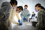Doctors test hospital staff with flu-like symptoms for coronavirus in set-up tents outside St. Barnabas hospital in the Bronx, New York, on March 24.