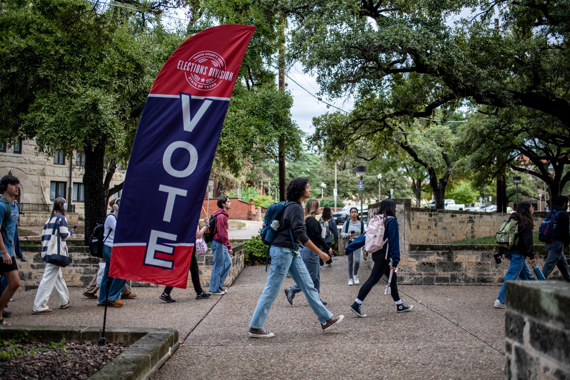 Students and voters walk past a "Vote" sign near a polling location in Austin, Nov. 5, 2024. 