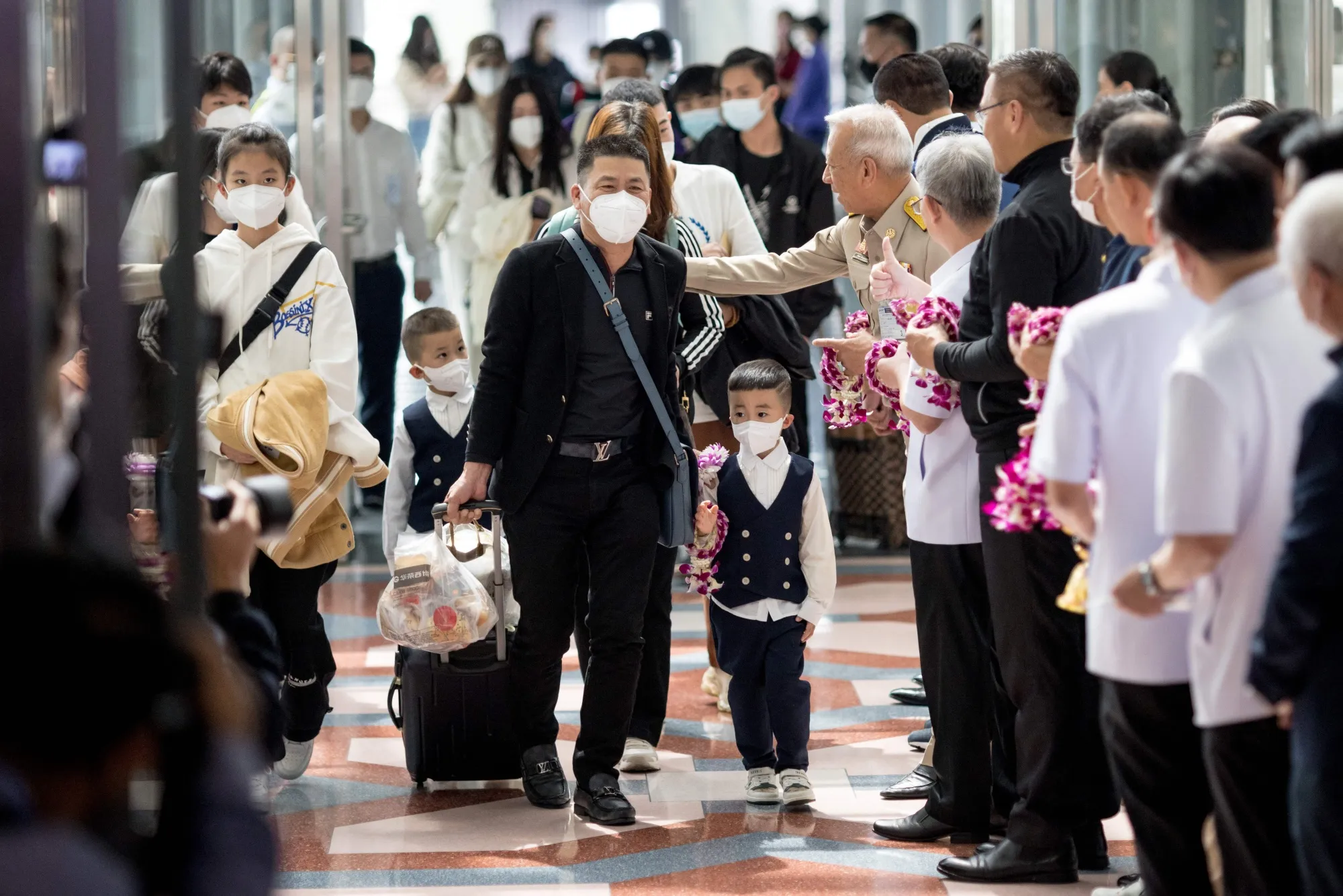 Travellers from China are greeted by Thai officials as they arrive at Suvarnabhumi Airport in Bangkok on Jan. 9.